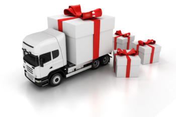 2D concept image of a white truck, with a big present as the cargo container, and a big present on a white background. Surrounded by 3 additional white present boxes, wrapped in red ribbon.